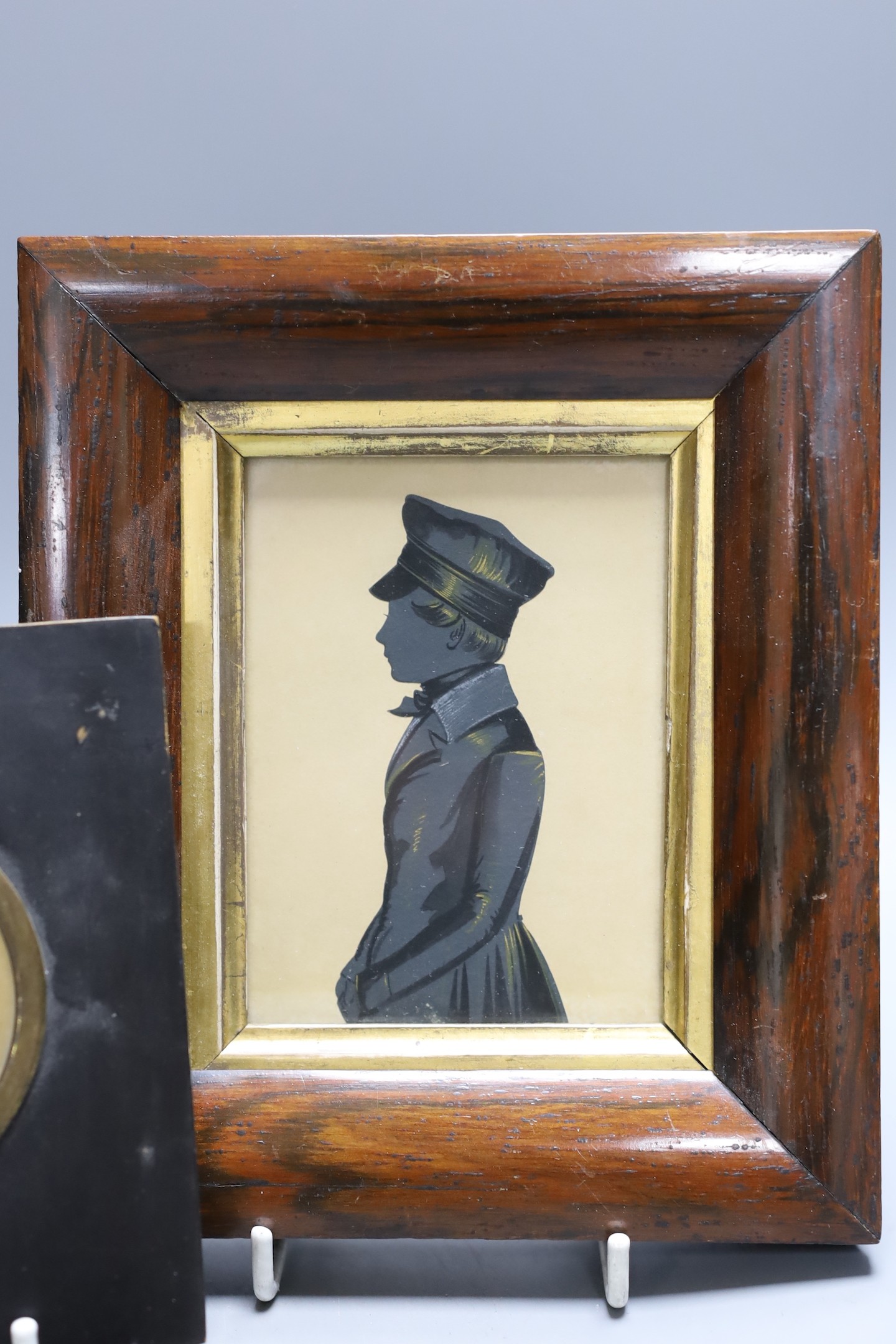 An unusual portrait miniature of a 19th century gentleman wearing earrings, together with two framed silhouettes (3)